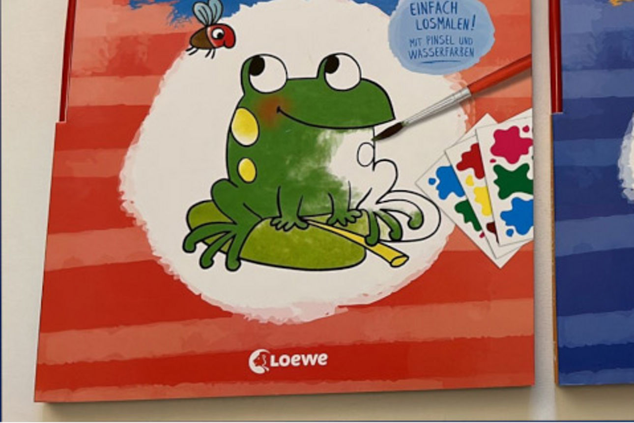 Zwei Malbücher, eines mit einem Frosch und ein anderes mit einer Rakete