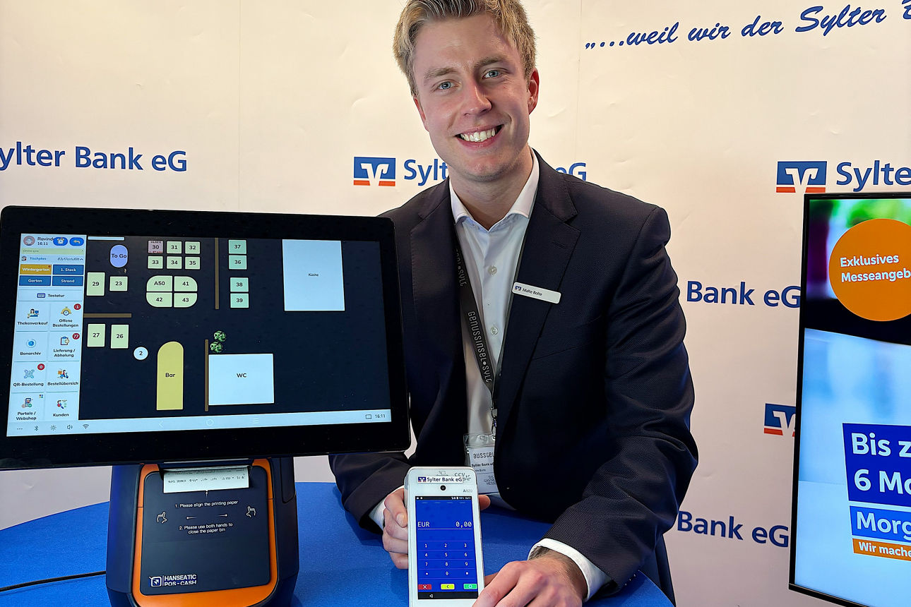 Ein Mann zeigt ein Kartenterminal und ein Kassensystem