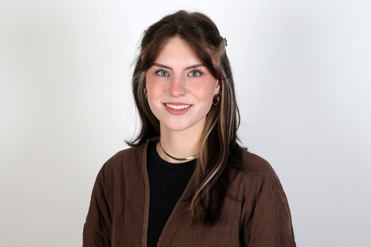 Eine lächelnder Frau schaut in die Kamera.