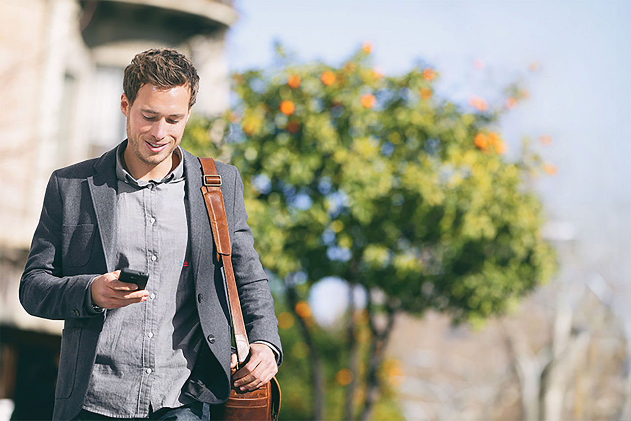 Mann mit Smartphone und Tasche läuft