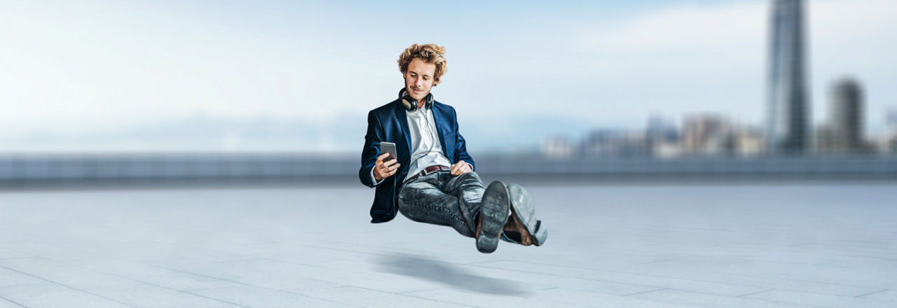 Ein Mann schwebt mit Handy in der Hand.