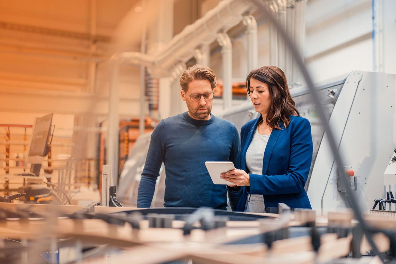 Beraterin und Geschäftsführer arbeiten im Büro an einem Whiteboard.