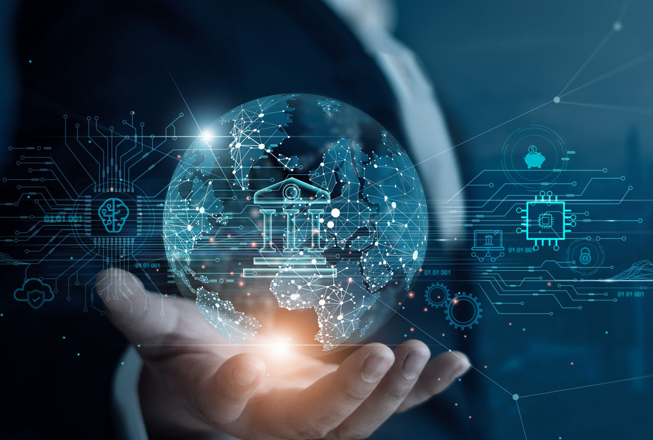 Mann im Anzug hält digitale Weltkugel mit Symbolen für Bank, Technologie und Vernetzung in der Hand.