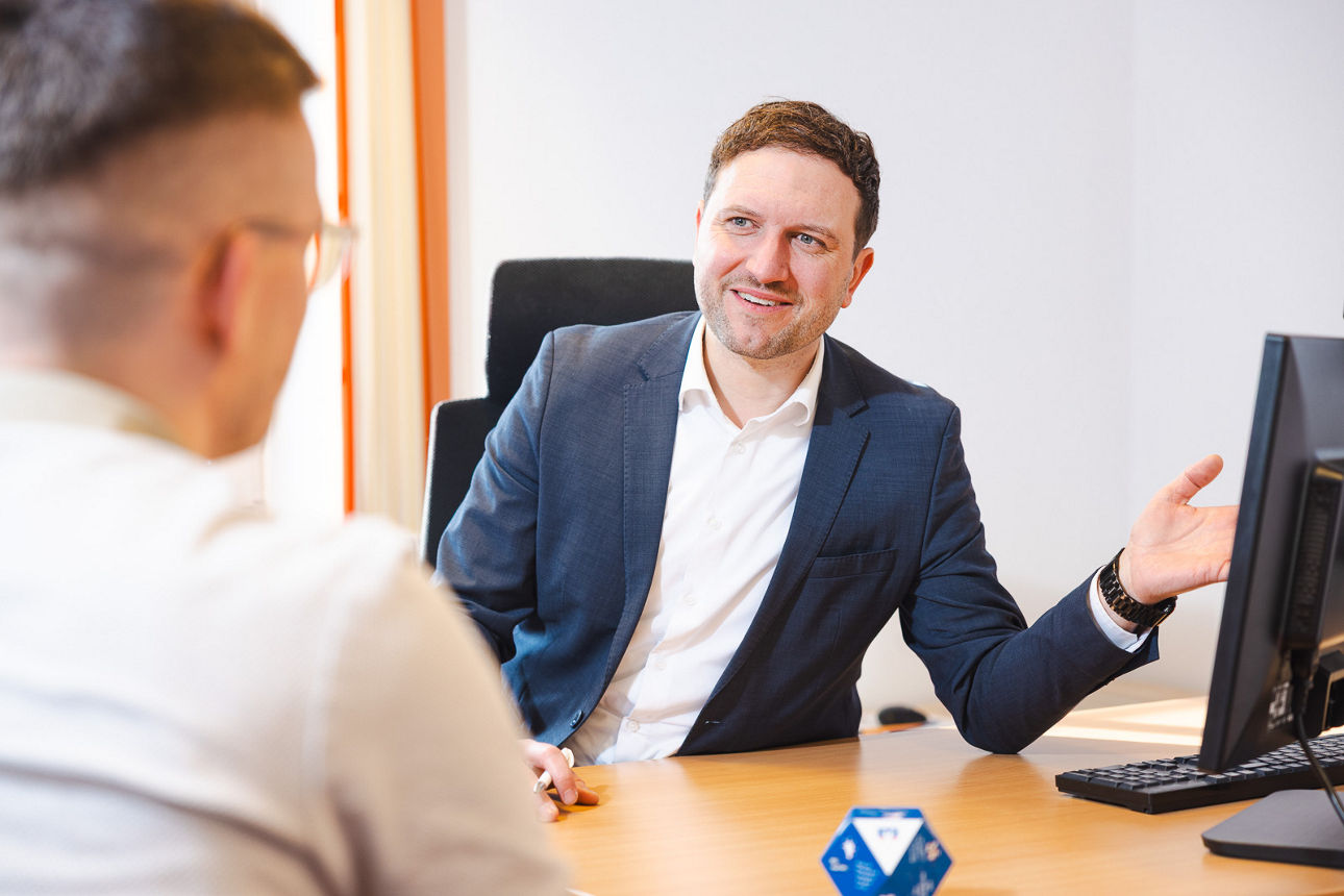zwei Männer in einem Beratungsgespräch am Schreibtisch