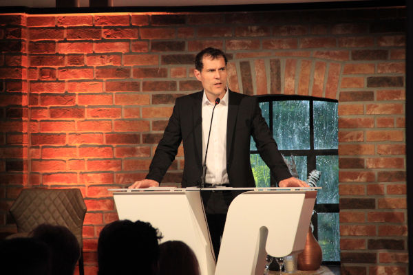 Marcus Feldhaar steht auf einer Kanzel und hält eine Rede