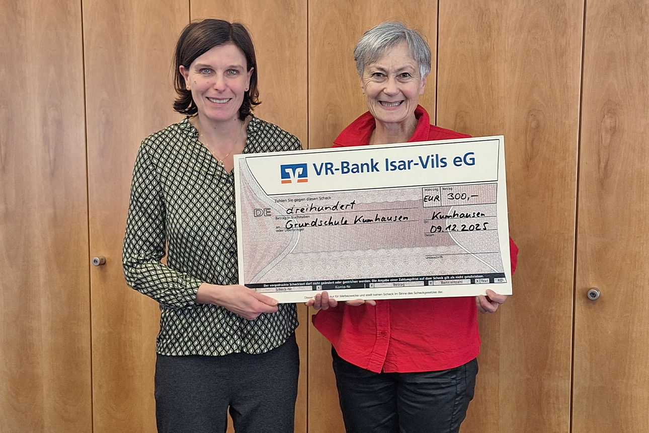 Zwei Frauen lächeln in die Kamera. Sie halten einen Riesenspendenscheck in der Hand.