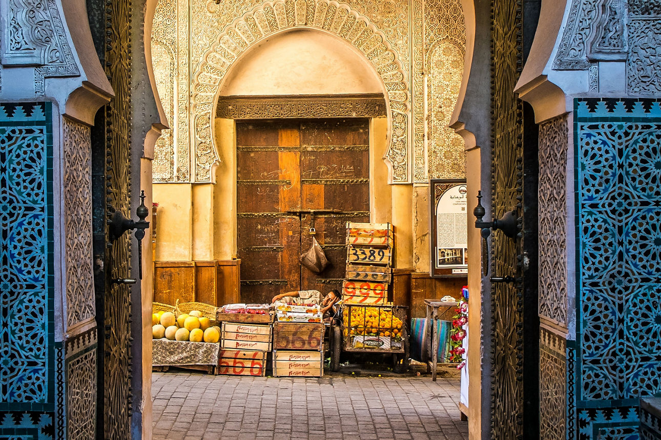 Marokkanisches Haus traditionell mit Gold verziert und ein Obsthändler der Obst verkauft