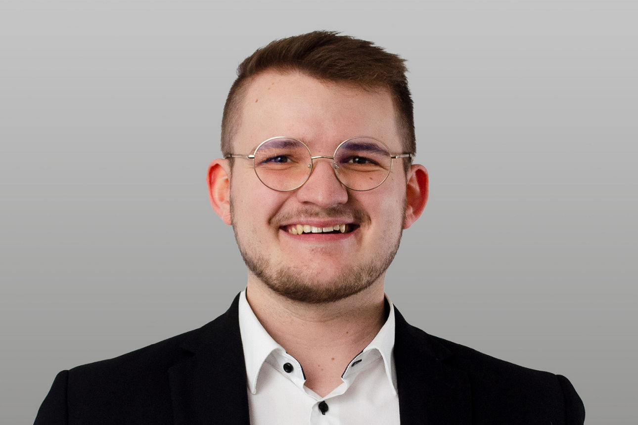 Privatkundenberater Florian Martens vor grauen Hintergrund