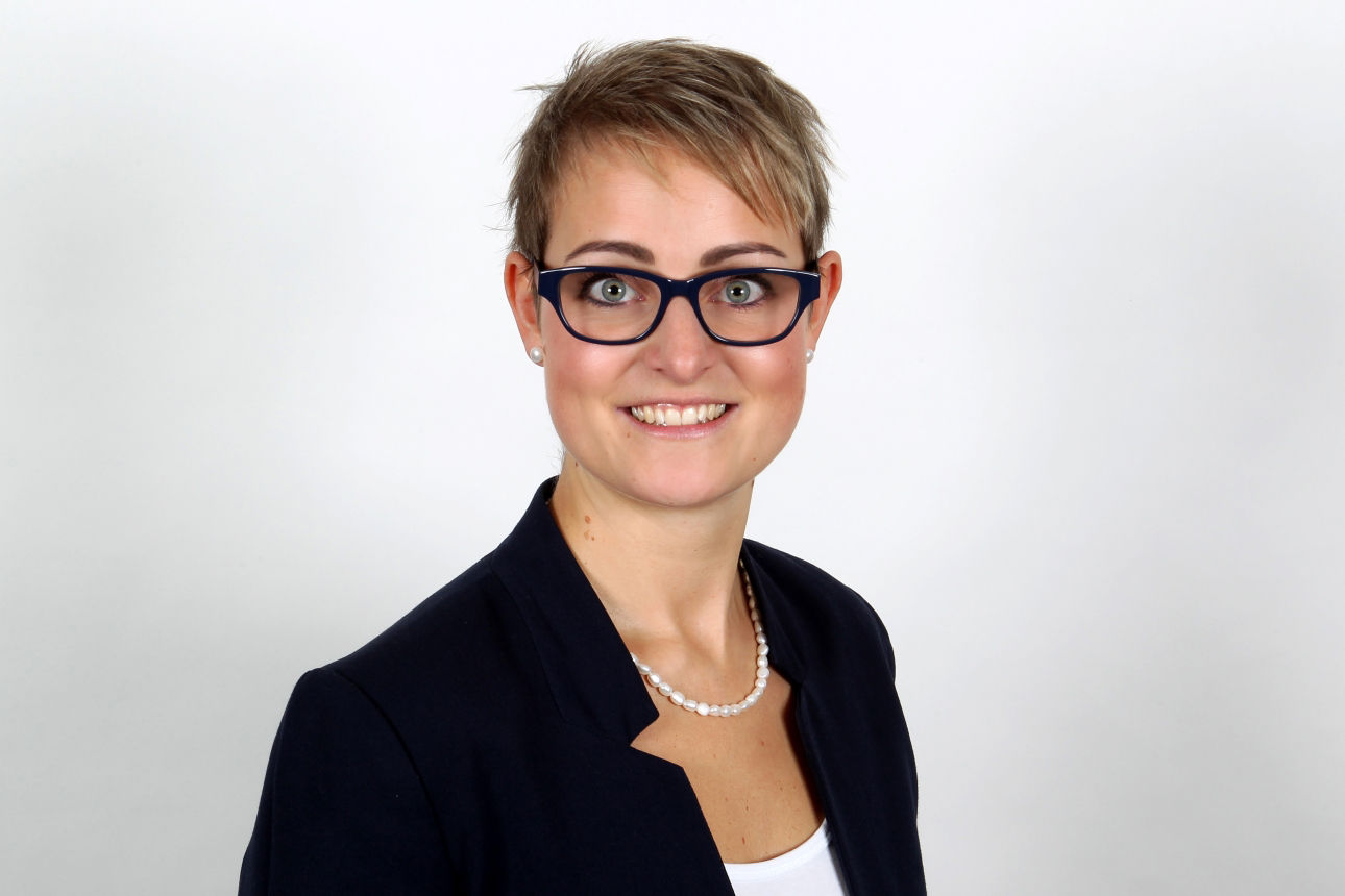 Eine lächelnde Frau schaut in die Kamera.