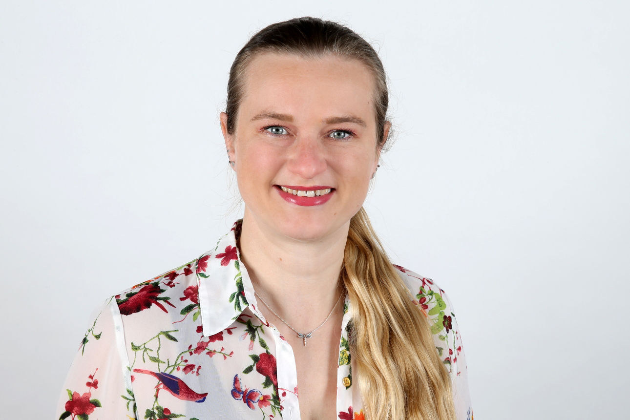 Eine lächelnde Frau schaut in die Kamera.