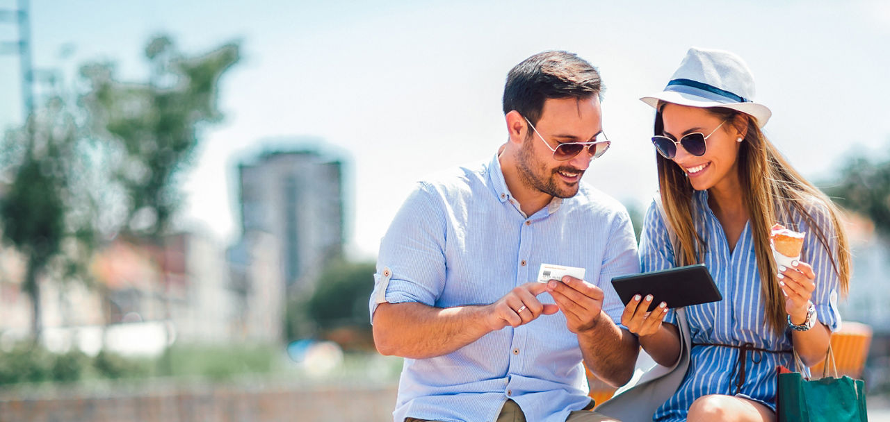 Ein Mann und eine Frau halten ein Smartphone und eine Kreditkarte in der Hand