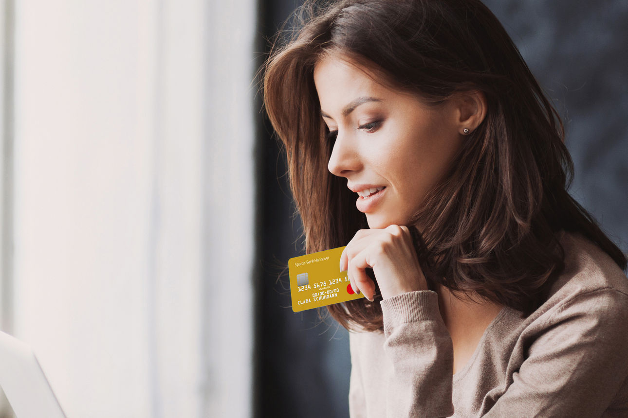 Eine Frau hält eine Mastercard Gold in der Hand