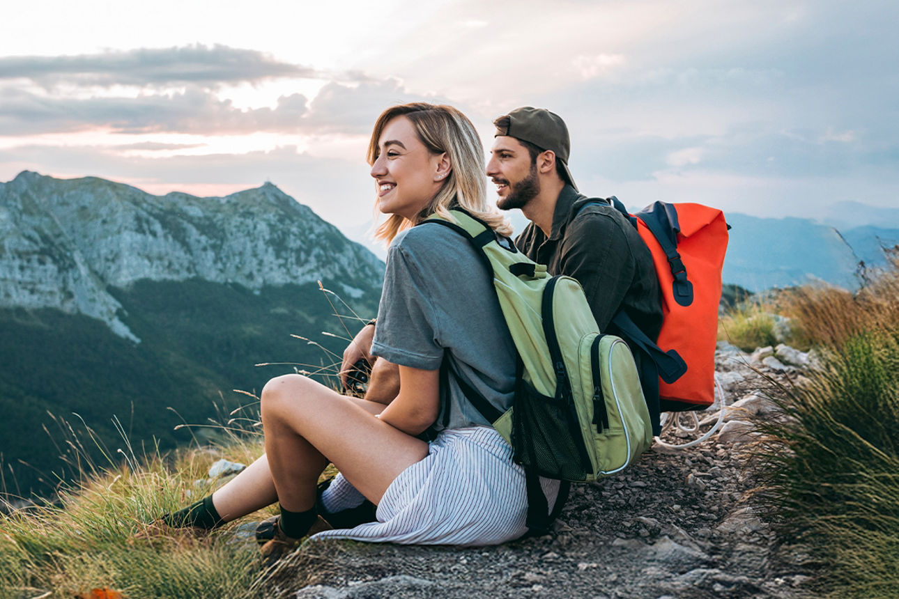 Zwei junge Erwachsene sitzen auf einem Berg