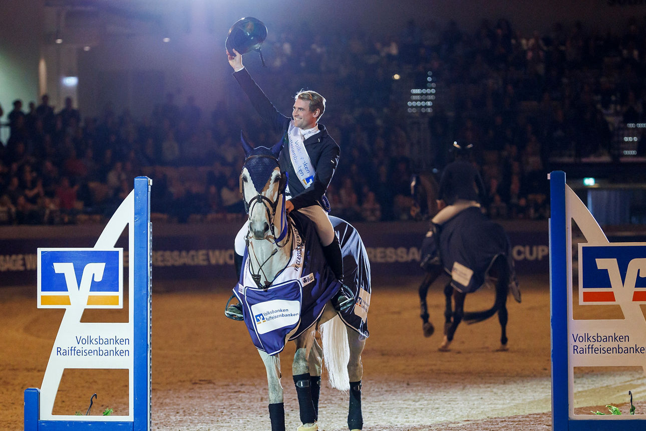 Reiter auf einem Pferd, welches zwischen zwei Sprungständern steht