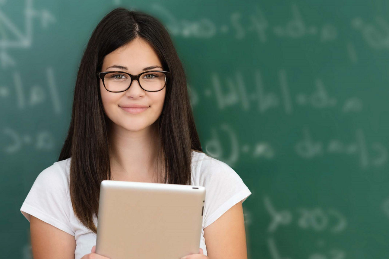 Frau mit Tablet vor einer Schultafel