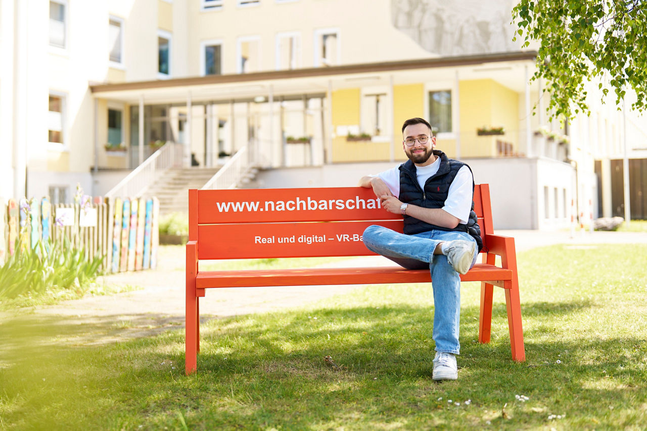 Max Müller sitzt auf einer Bank im Grünen