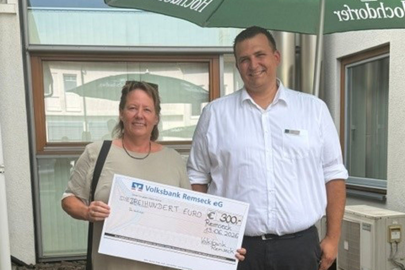 Ein Mann und eine Frau posieren mit einem symbolischen Scheck über 300 Euro von der Volksbank Remseck eG.