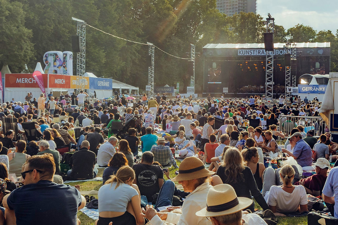 Feiernde Menschenmenge bei einem Konzert vor einer Bühne