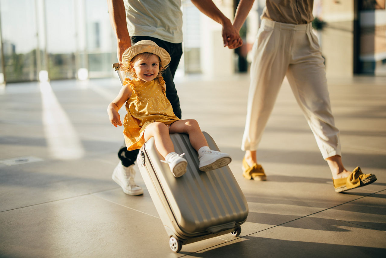 Kind fährt auf einem Trolley Koffer.