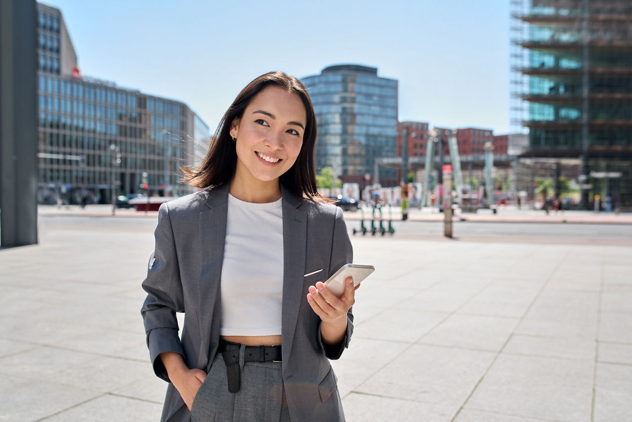 Junge Frau benutzt den Anlage-Assistent MeinInvest per Smartphone