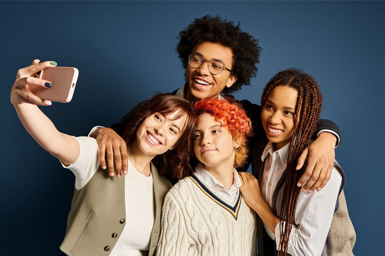 Vier junge Menschen stehen zusammen und machen ein Selfie