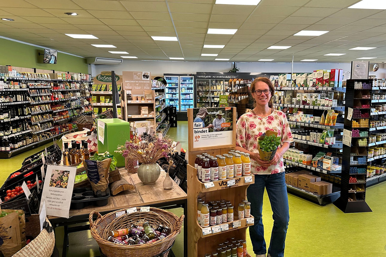 MeinPlus Cashback, Dame steht mit Kräutern in der Hand in einem Naturkostladen