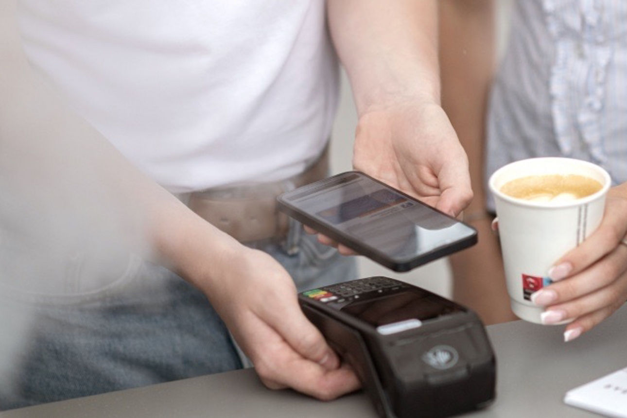 Kontaktloses Bezahlen eines Kaffees mit dem Handy
