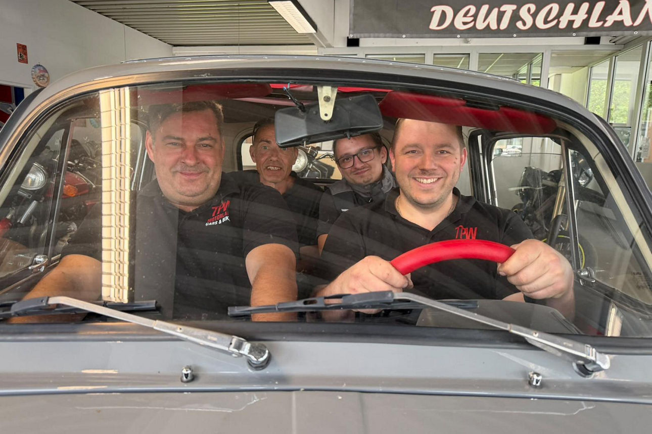 Vier lachende Männer in einem Auto