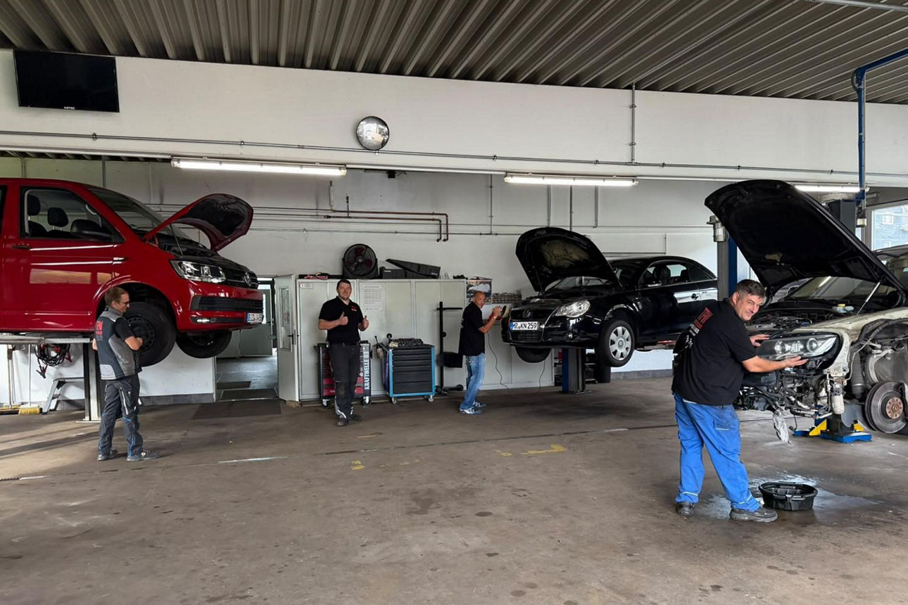 Vier Männer in einer Autowerkstatt