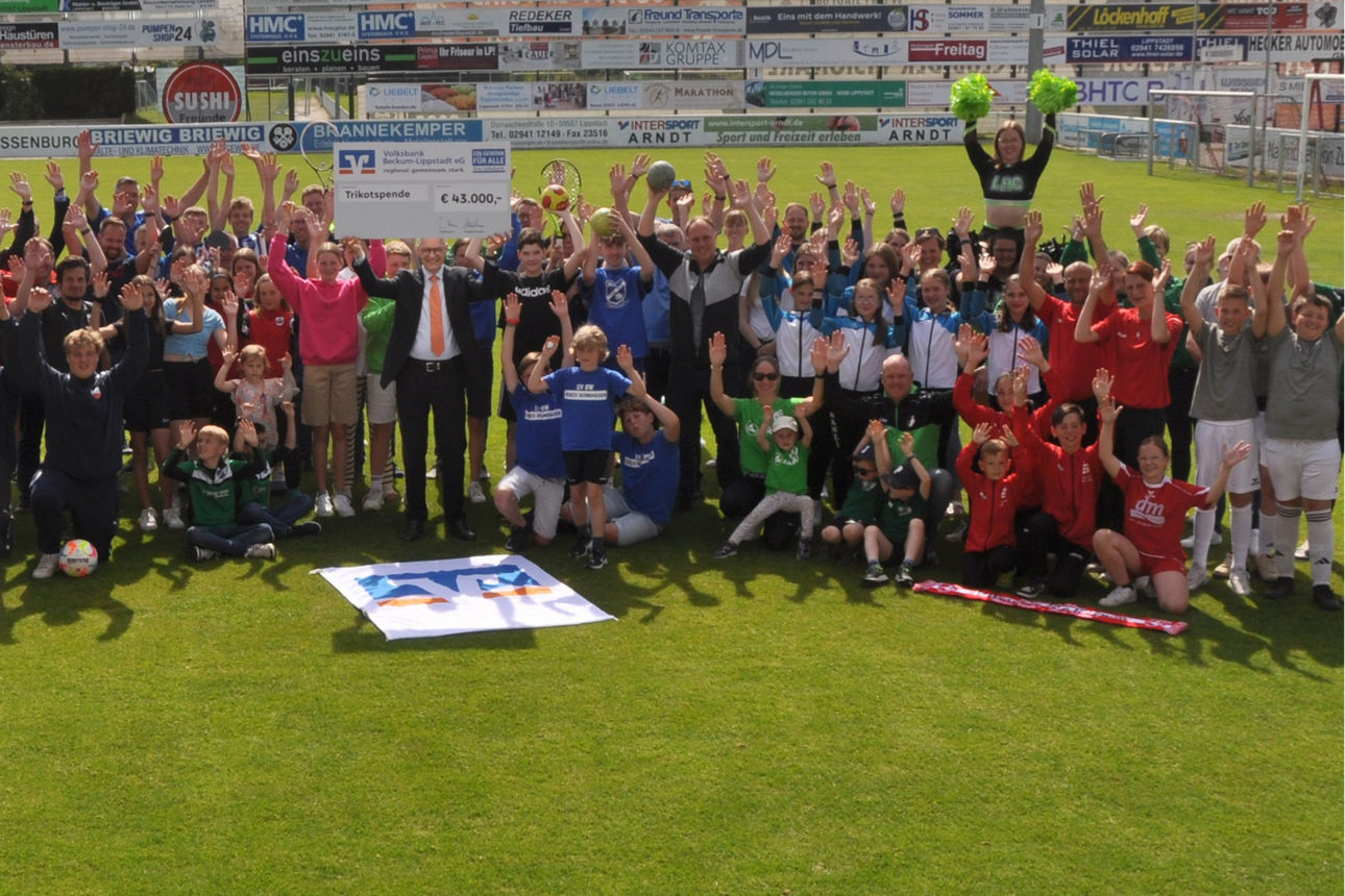 Die Vertreter etlicher Vereine unserer Region stehen gemeinsam auf einem Fußballfeld und jubeln