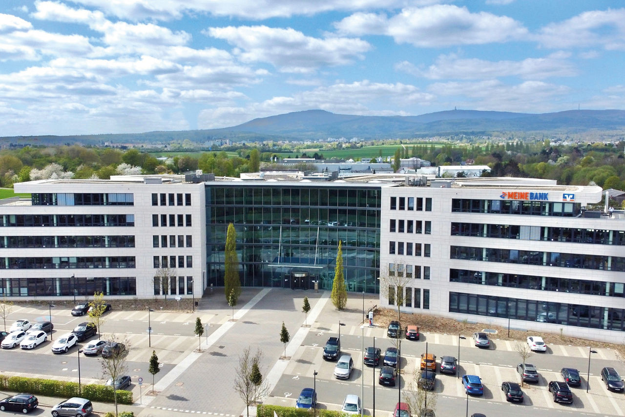 Abbildung zeigt Geschäftsgebäude von Meine Bank mit Hochtaunus im Hintergrund