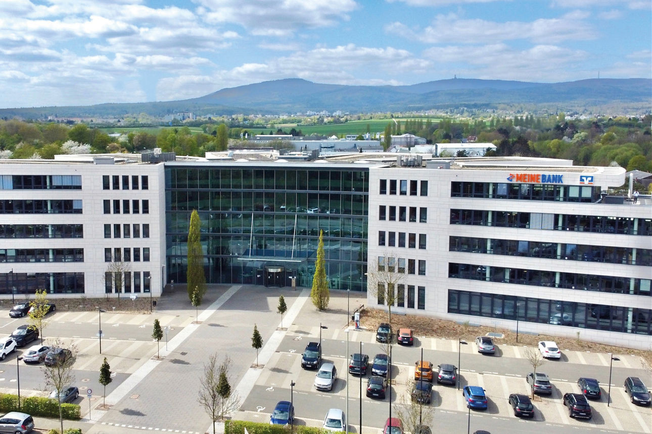 Abbildung zeigt Geschäftsgebäude von Meine Bank mit Hochtaunus im Hintergrund