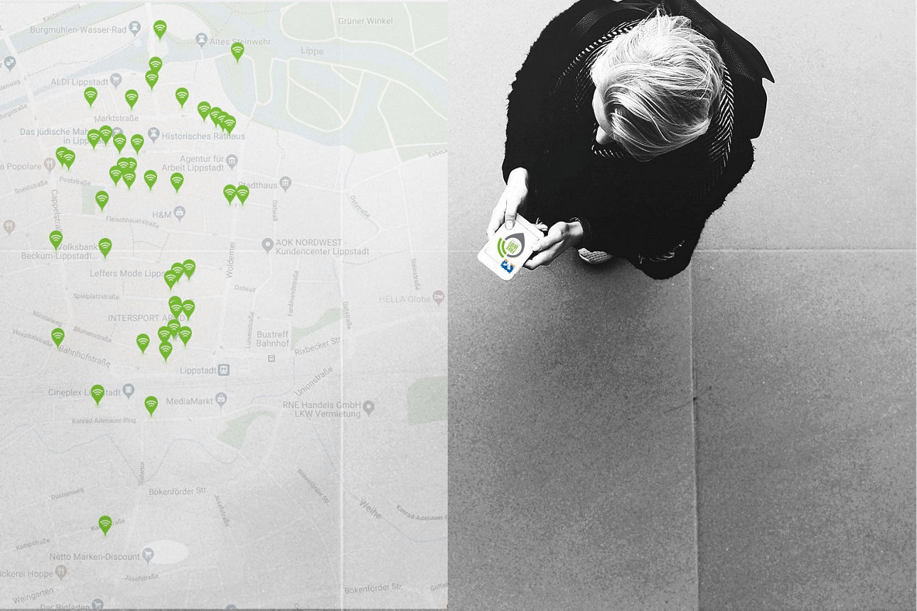 Eine Person steht auf einem Gehweg und verbindet sein Handy mit dem regionalen WLAN