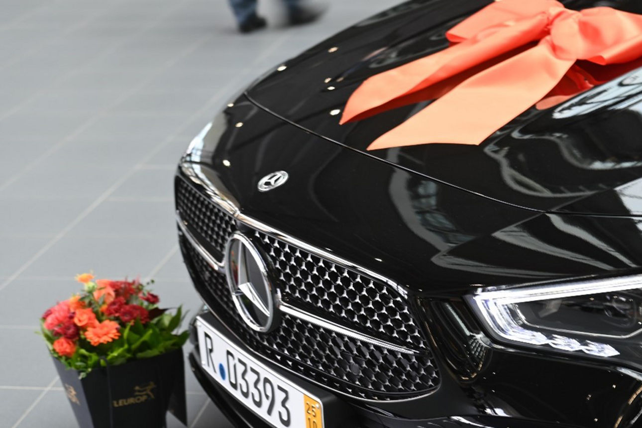 Ein schnittiger, schwarzer Mercedes-Benz glänzt in einem Ausstellungsraum