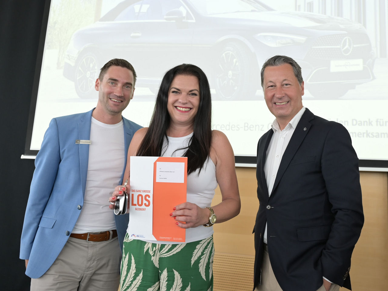 Frau bekommt von zwei Männern einen Autoschlüssel geschenkt