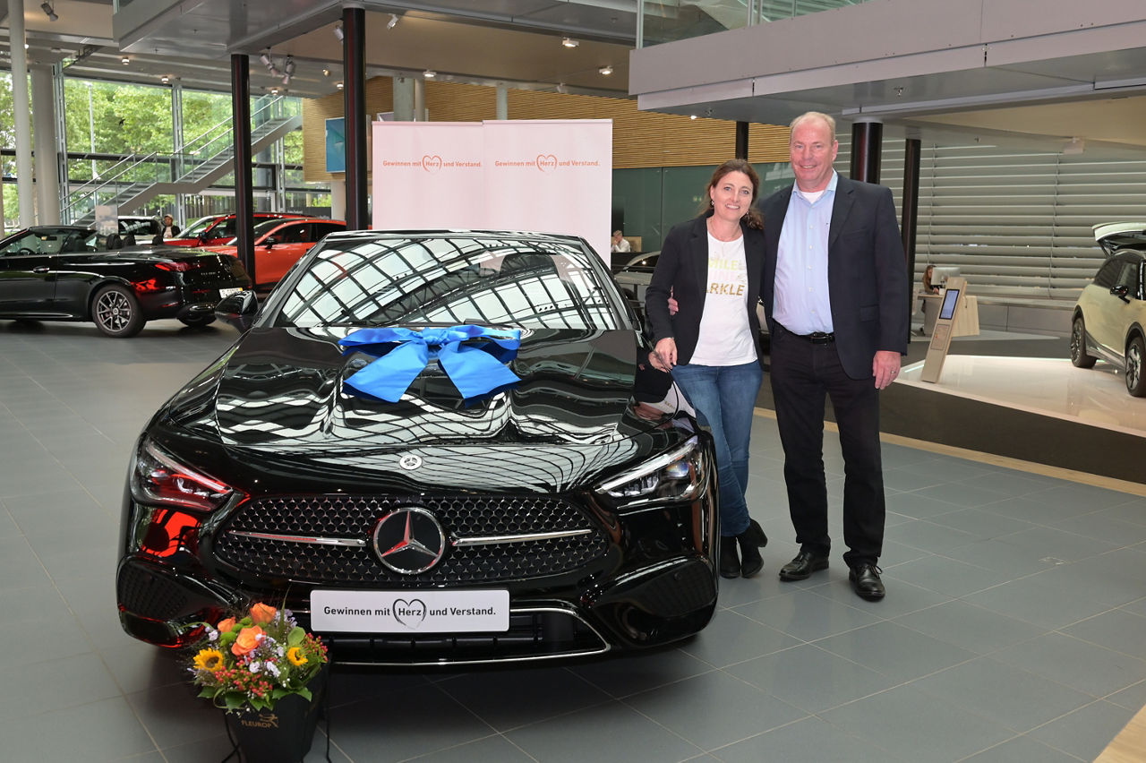 Mann und Frau neben einem Mercedes Benz CLE 200 Cabriolet