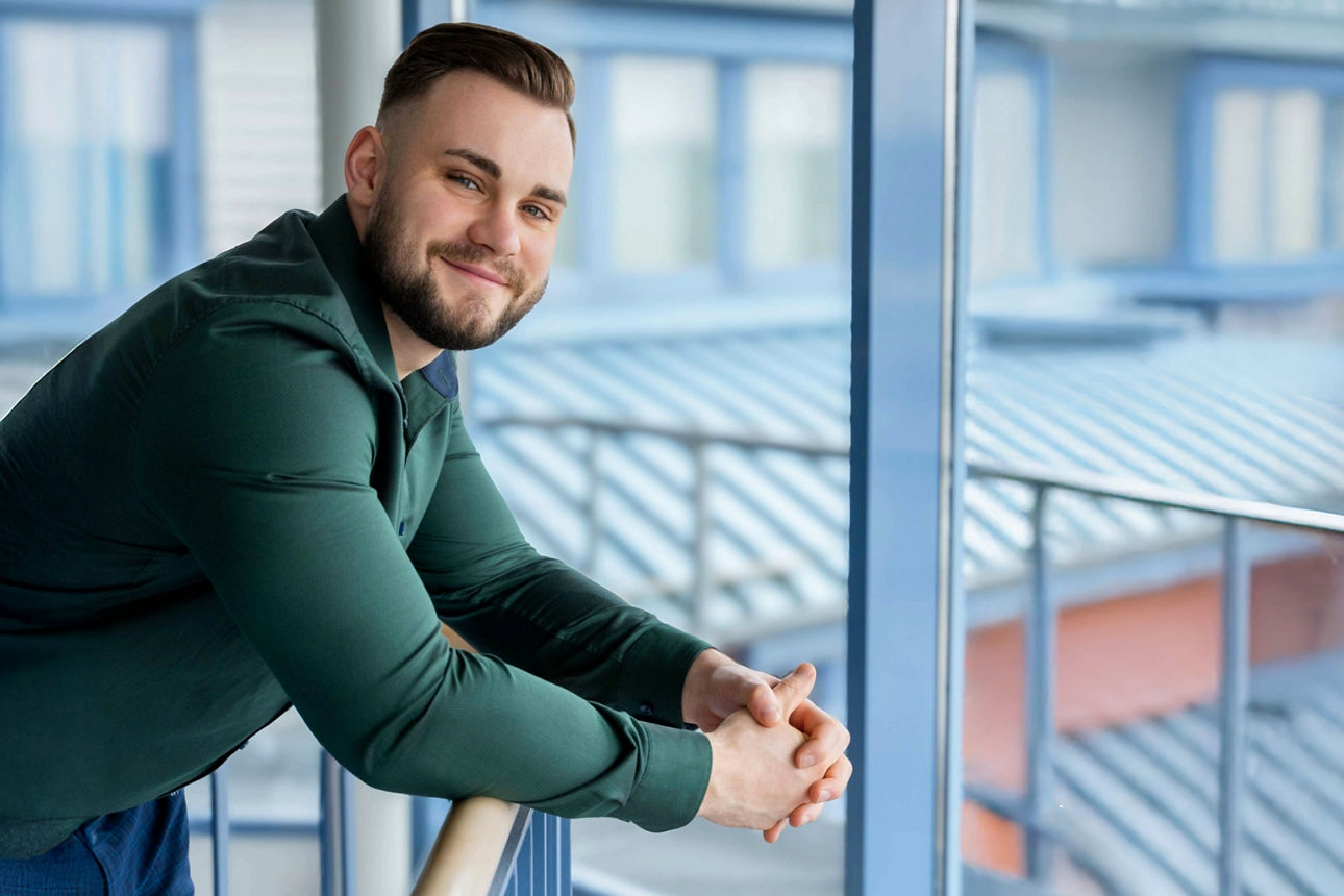 Junger Mann lehnt über ein Geländer