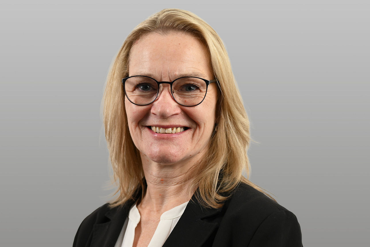 Servicemitarbeiterin Sabine Messerschmidt vor grauen Hintergrund