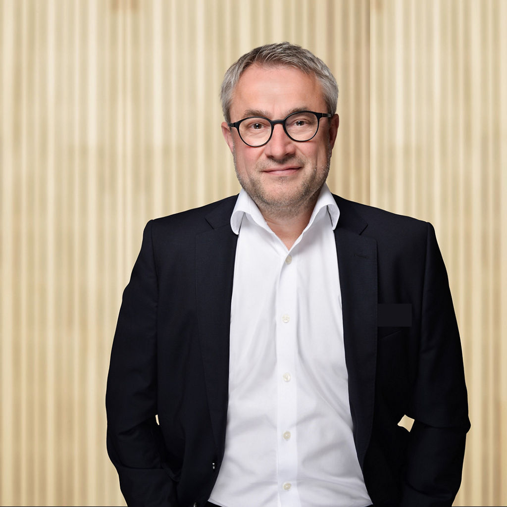 Michael Lutz vor einer Holzwand