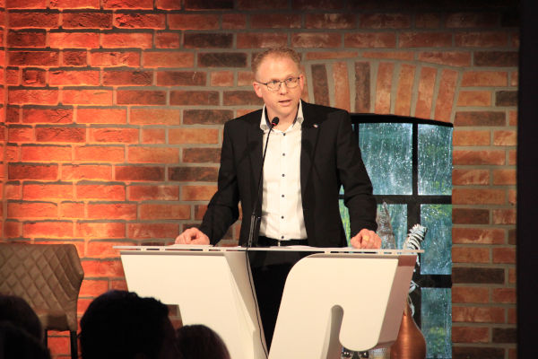 Michael Weddeling steht auf einer Kanzel und hält eine Rede