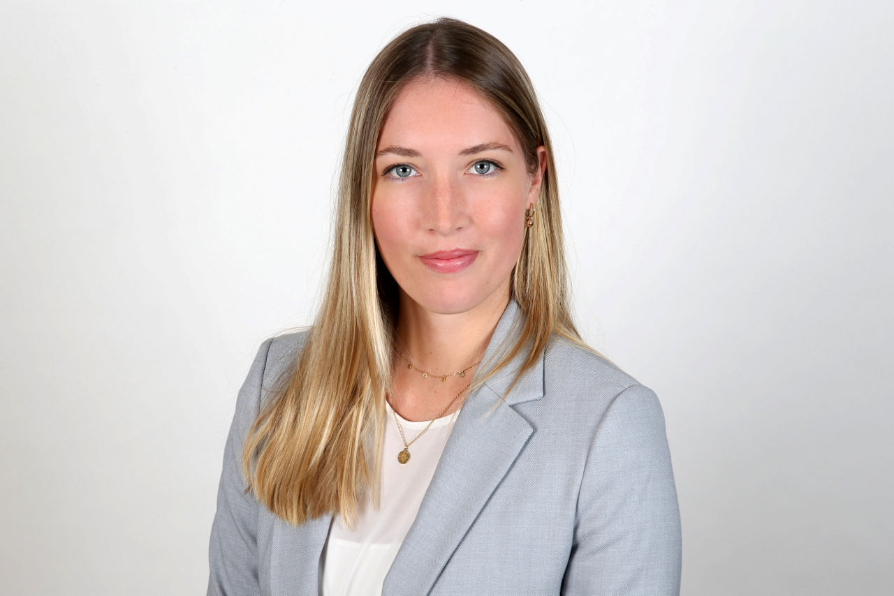 Eine lächelnder Frau schaut in die Kamera.