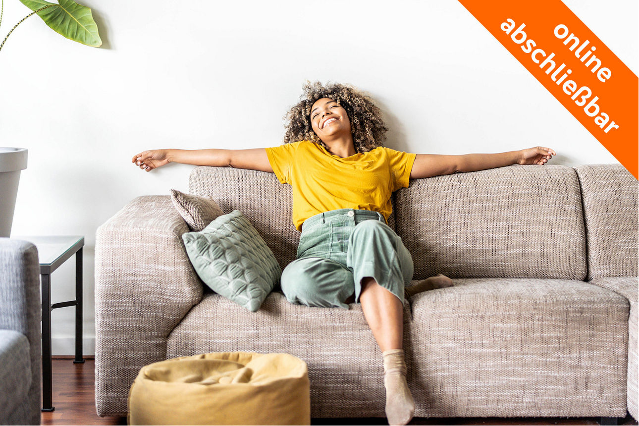 junge Frau liegt glücklich auf der Couch