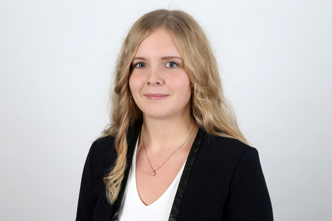 Eine lächelnde Frau schaut in die Kamera.