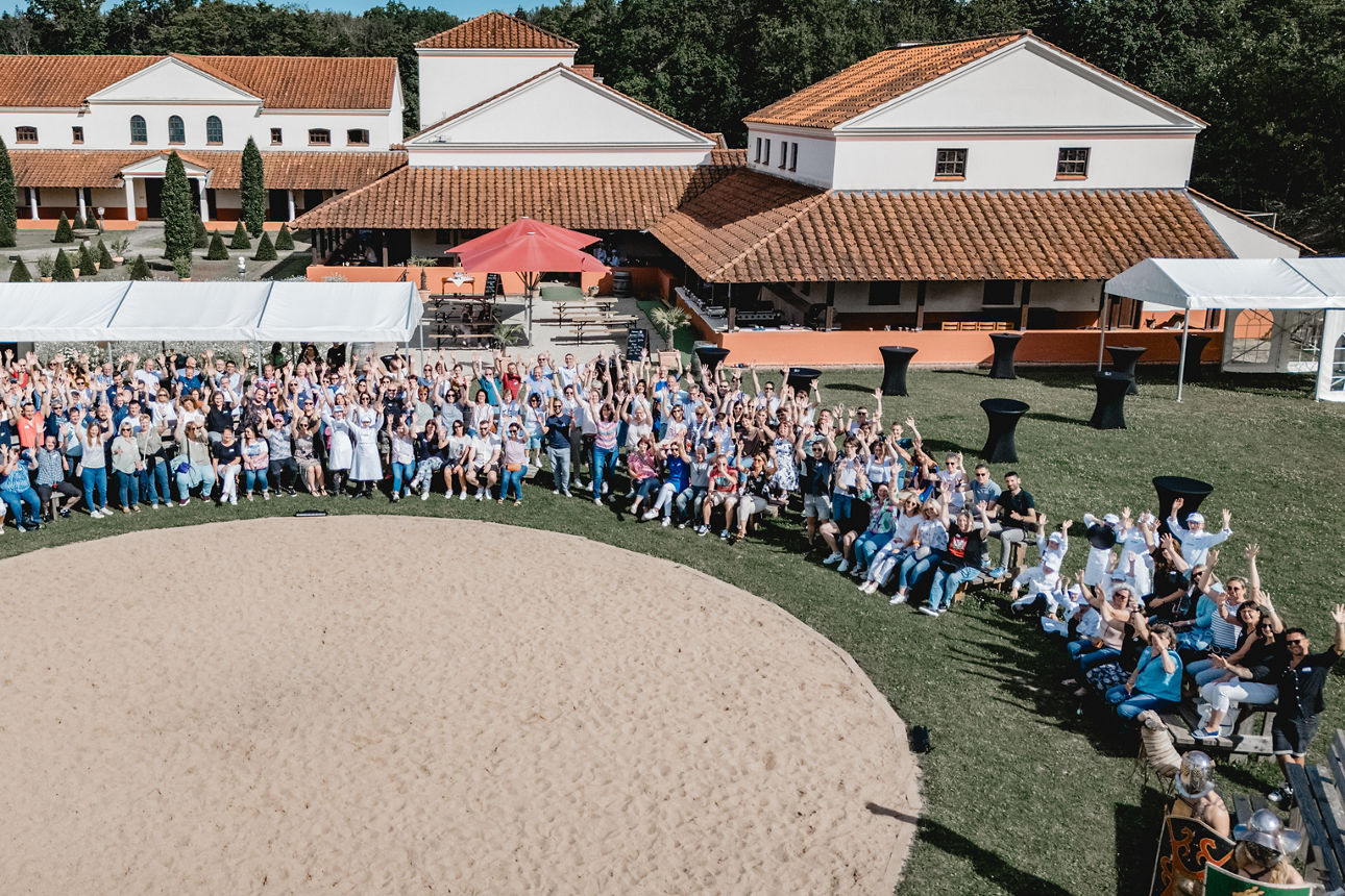 Alle Mitarbeiter der VVB stehen im Kreis auf dem Platz der Villa Borg