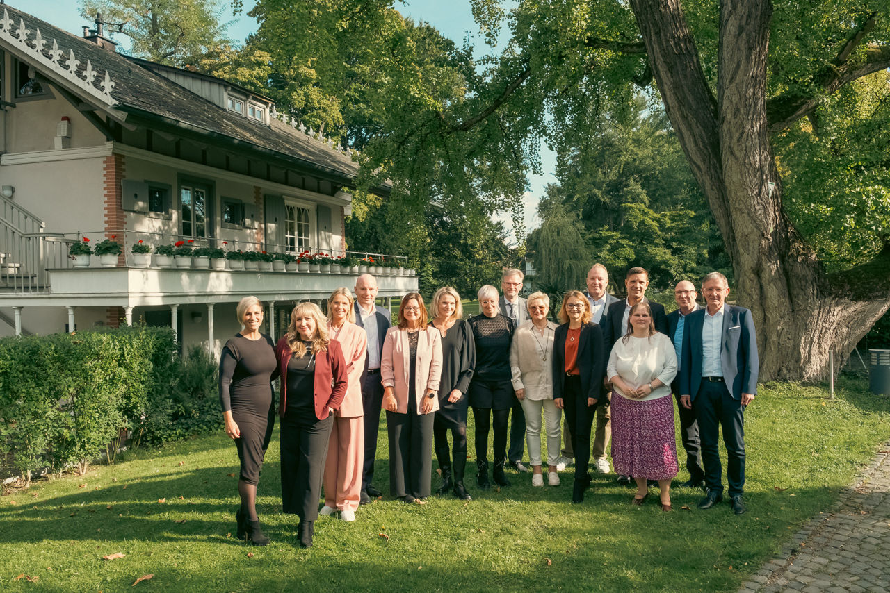 Mitarbeitende der Sparda-Bank Hessen stehend in Garten mit Vorstand zum Anlass des Mitarbeiterjubiläums
