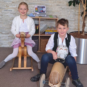 Kinder auf Schaukelpferd und Spielzeugauto