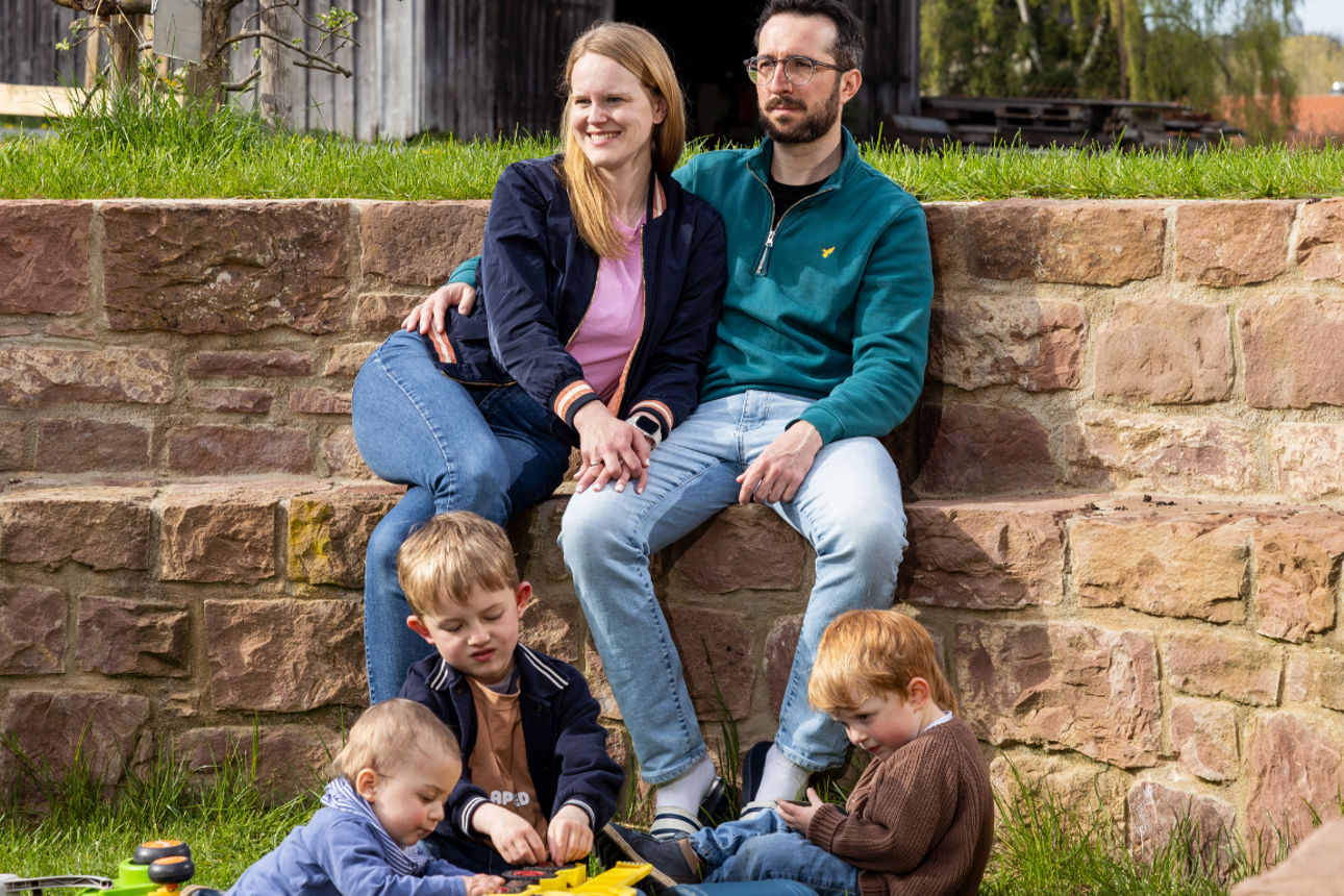 Ehepaar mit Kindern im Garten