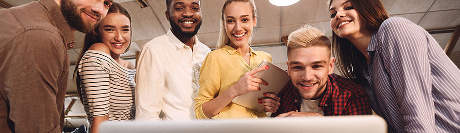 Drei junge Männer und drei junge Frauen schauen auf einen Laptop