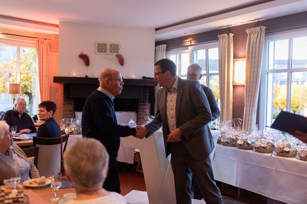 Norbert Scholtholt gibt einem Volksbank Mitglied die Hand