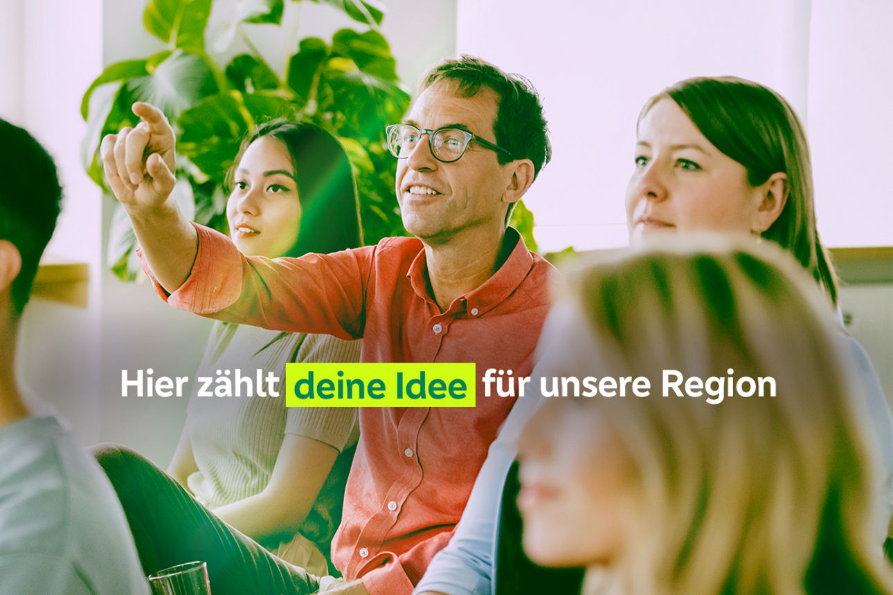 Mann meldet sich in einer Gruppe von Menschen zu Wort.